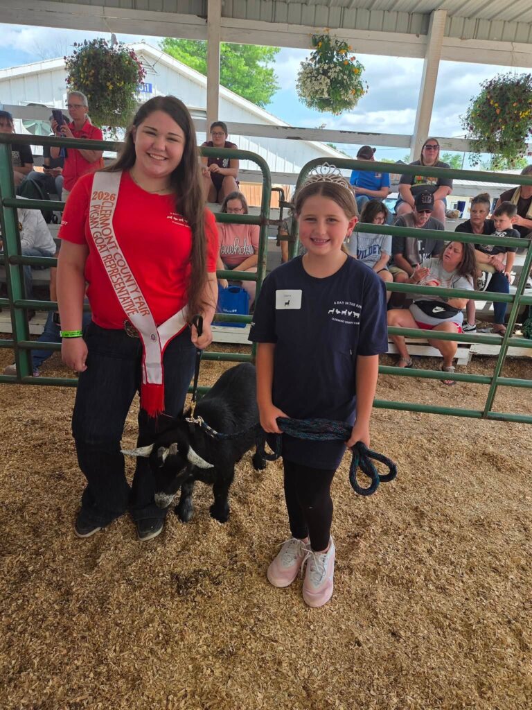 A young participant shows a goat with a 4-H mentor during A Day in the Ring