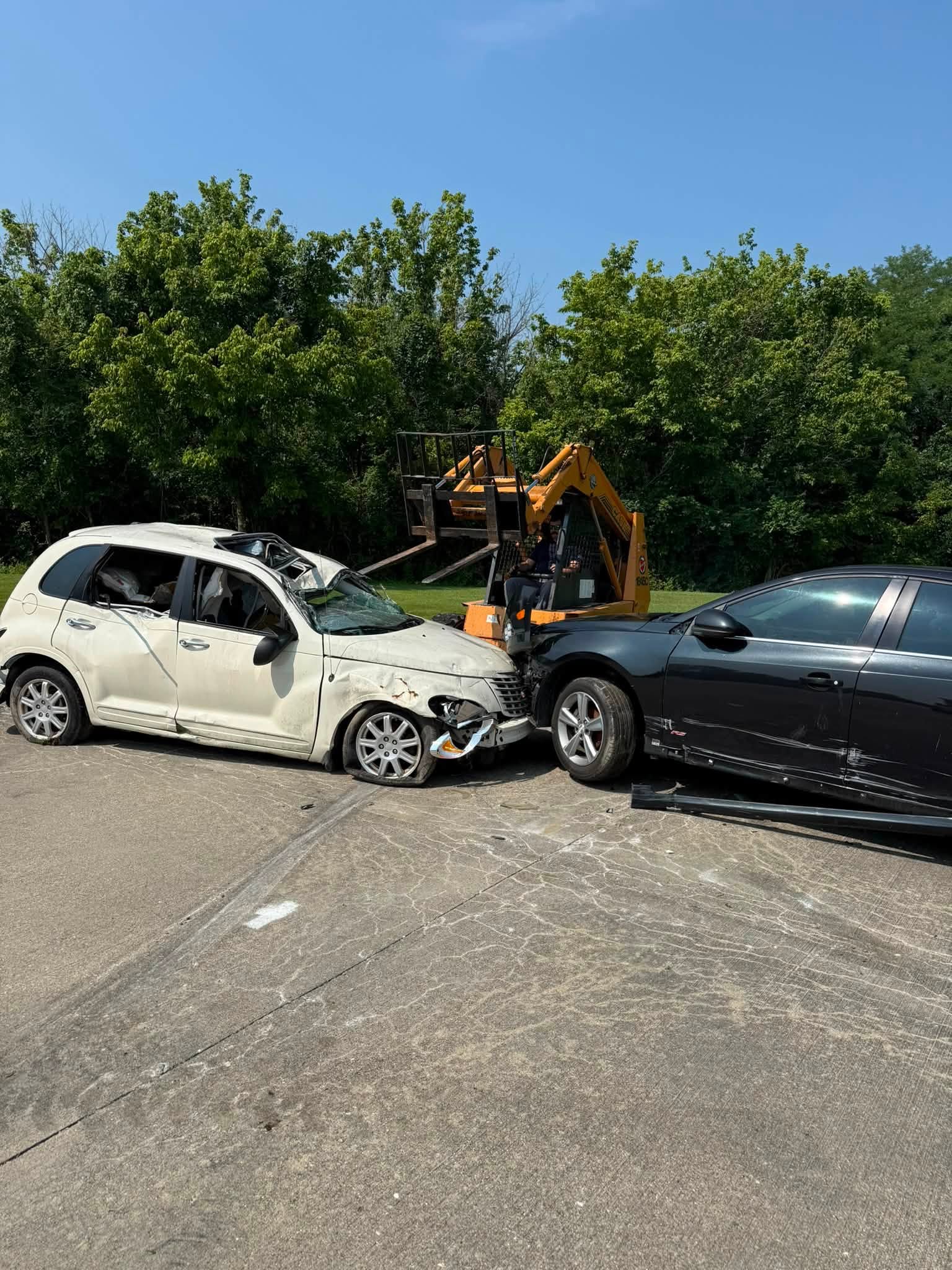 Crews use a skid loader to position wrecked vehicles for extrication training