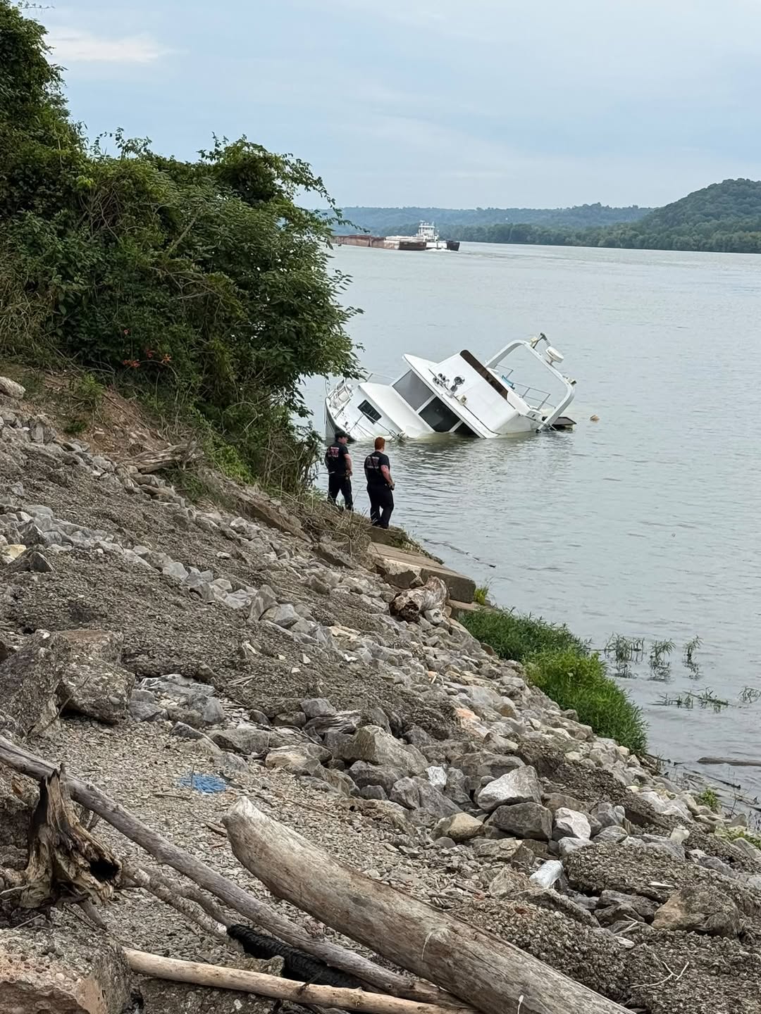 Crews inspect partially submerged boat on the Ohio River near Chilo
