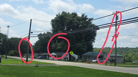 Leaning utility poles mark storm-damaged power lines in Clermont County