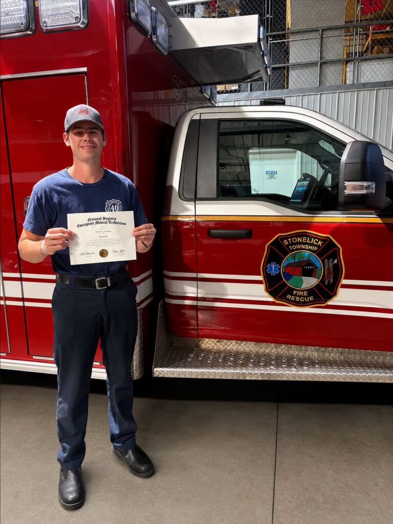 Parker Woolery holds his paramedic certification outside Station 40