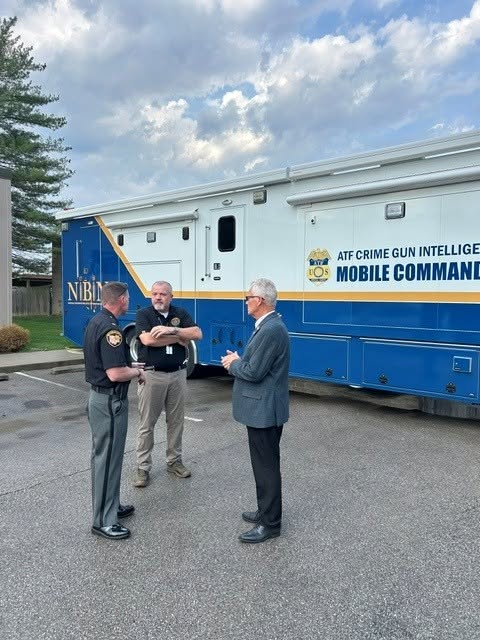 Sheriff Christopher Stratton speaks with ATF representatives beside the NIBIN-equipped mobile command vehicle