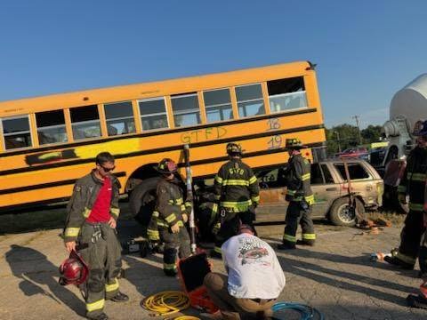 Goshen firefighters work an extrication drill beside a training bus