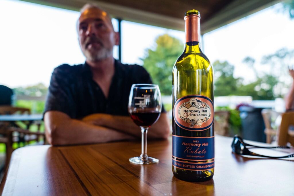 A glass and bottle of Harmony Hill wine at the Bethel vineyard