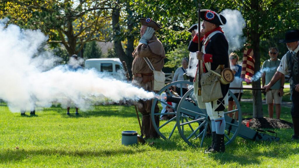 Revolutionary War reenactors fire a cannon at Veterans Memorial Park dedication