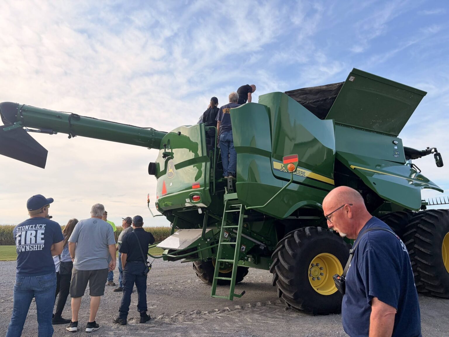 Firefighters climb aboard a John Deere combine during hands-on fire training