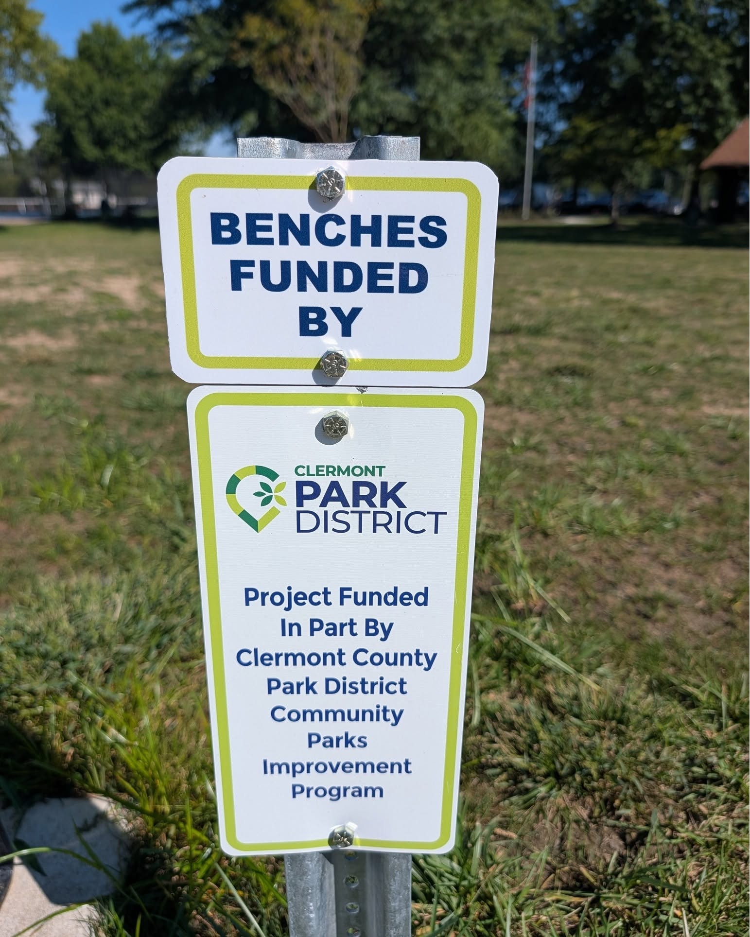 A sign credits the Clermont County Park District's Community Parks Improvement Program for funding new bench seating at Veterans Memorial Park