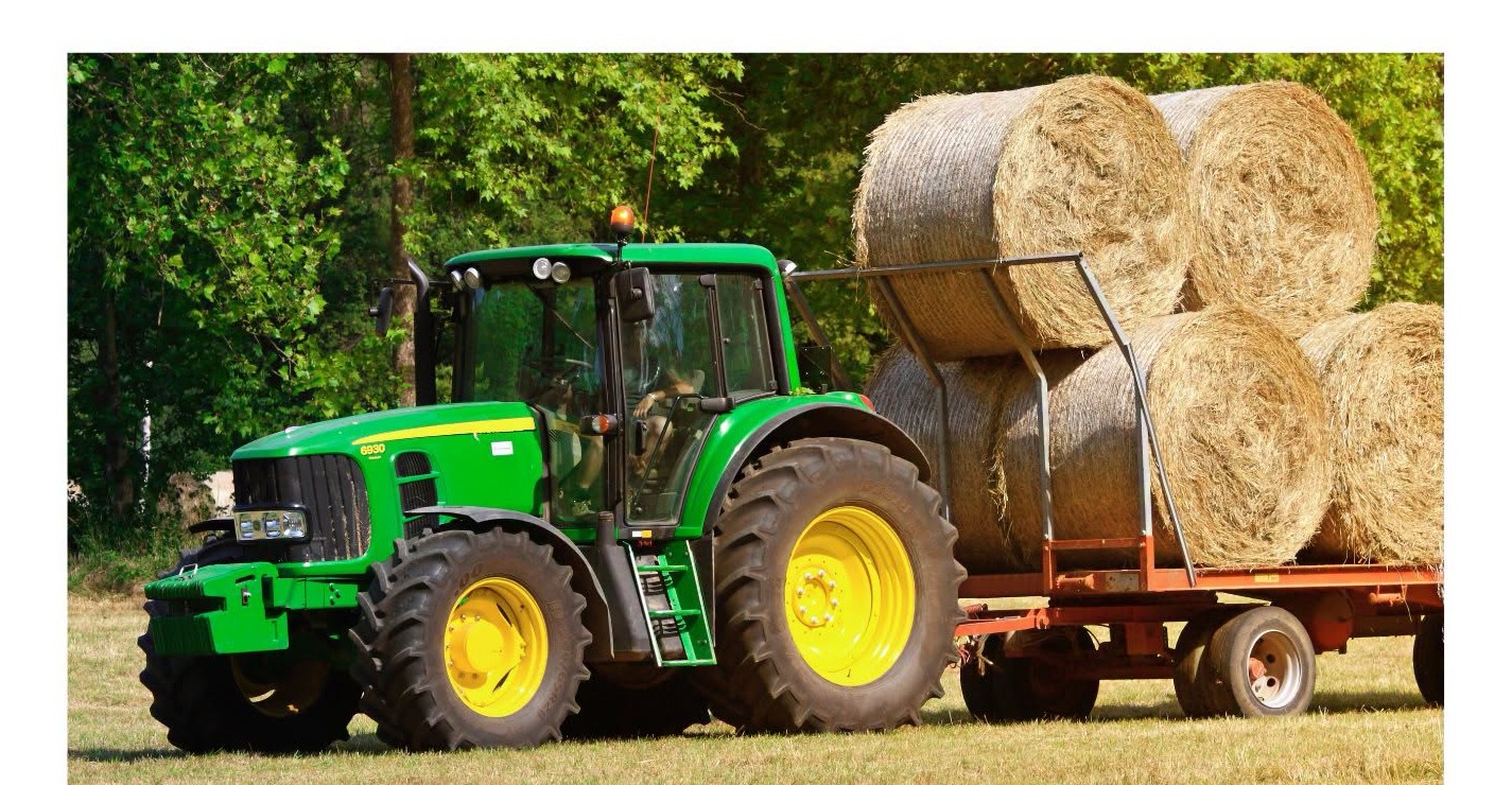A tractor hauls hay bales ahead of the Bethel library farm equipment event