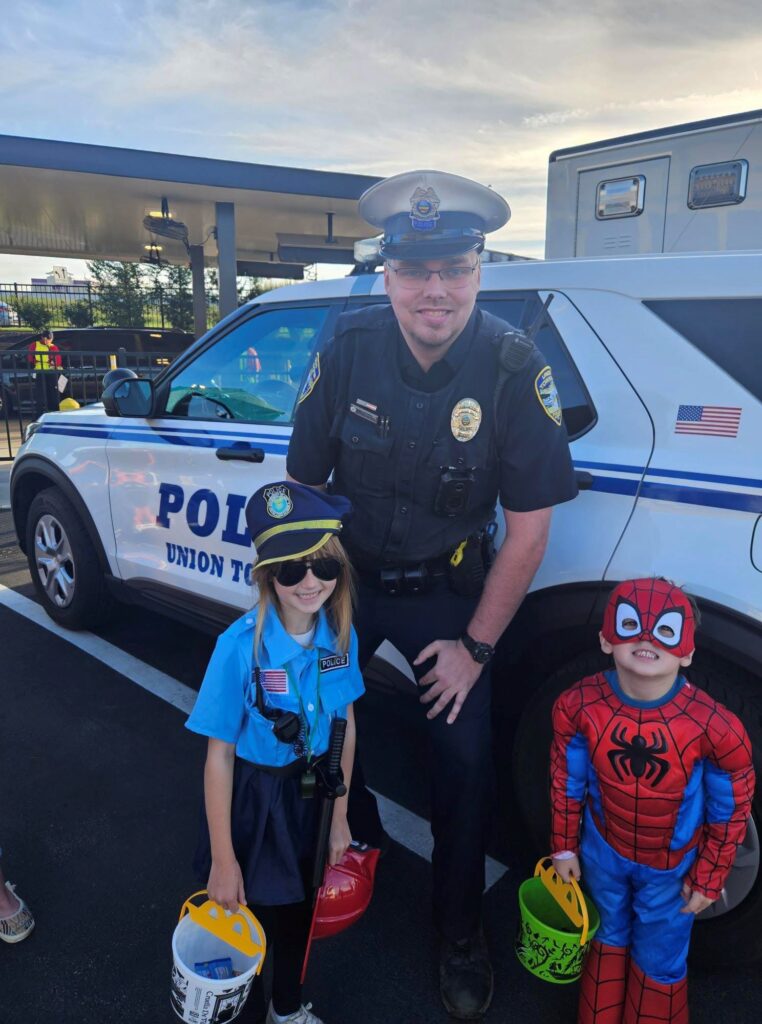 Union Township officer poses with trick-or-treaters in costume