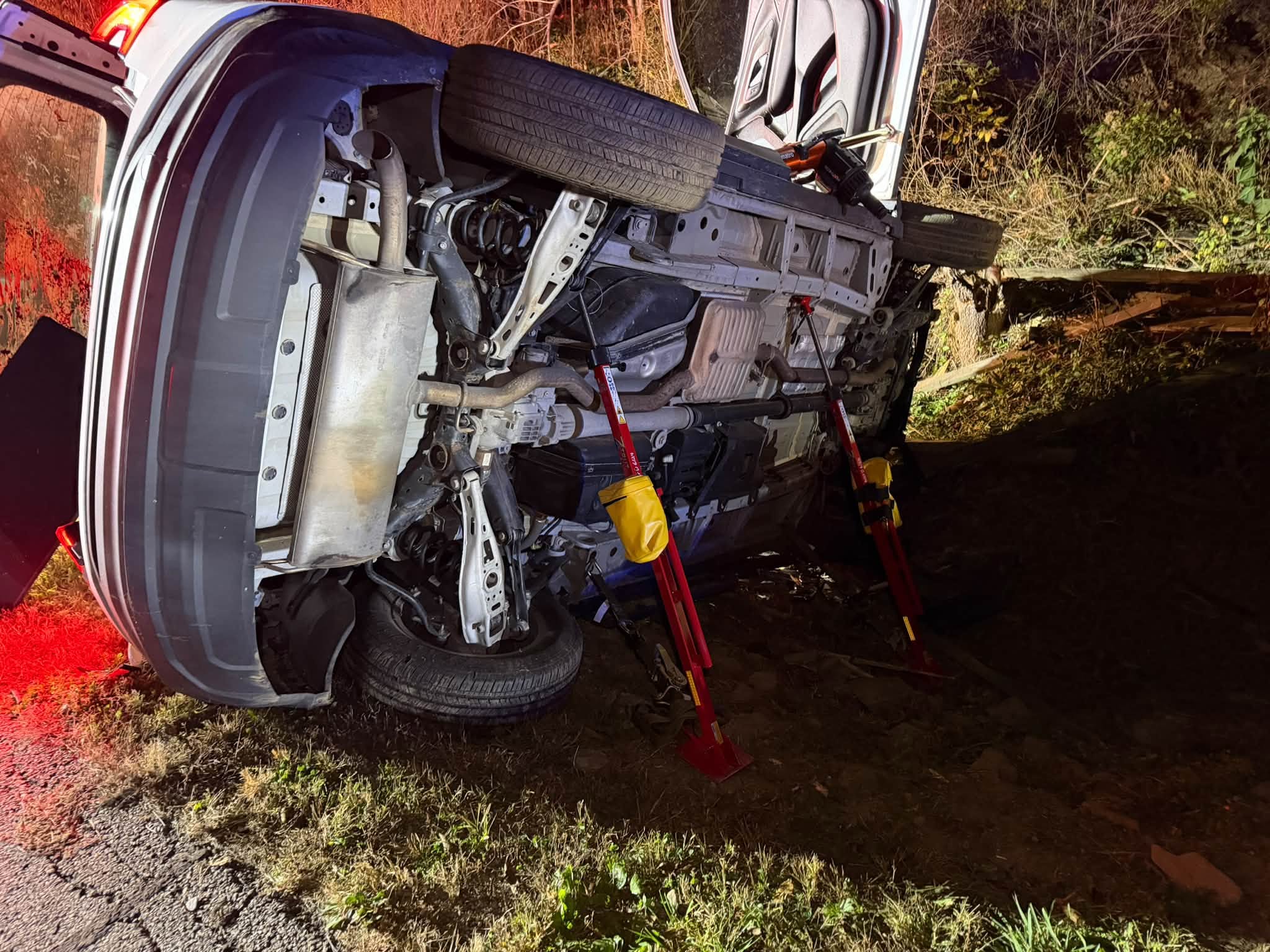 Crews stabilize the overturned vehicle before extrication